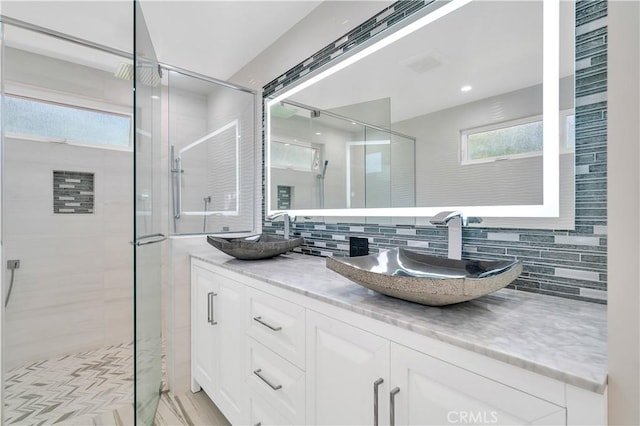 full bath featuring a stall shower, a sink, and decorative backsplash