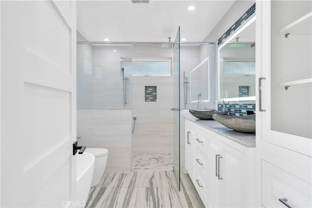 bathroom with double vanity, recessed lighting, a sink, and a shower stall