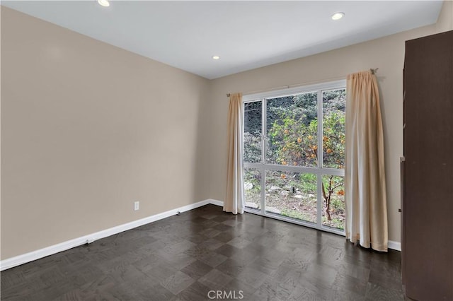 unfurnished room with recessed lighting and baseboards