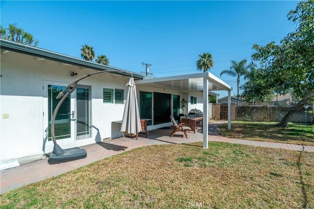 back of house with a patio, fence, french doors, a lawn, and stucco siding