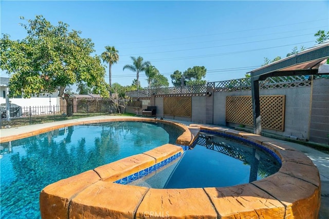 view of pool with a fenced backyard and a pool with connected hot tub