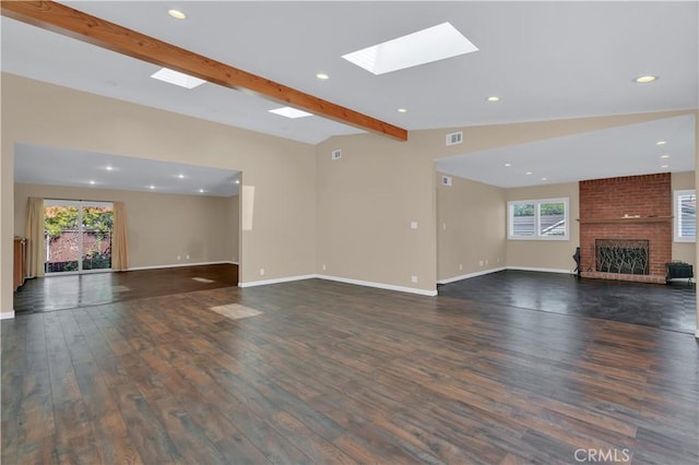 unfurnished living room with dark wood-style flooring, vaulted ceiling with beams, visible vents, a brick fireplace, and baseboards