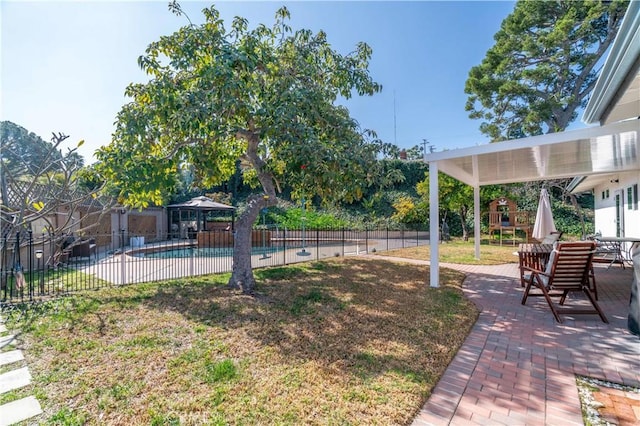 view of yard featuring a patio area, fence, and a fenced in pool