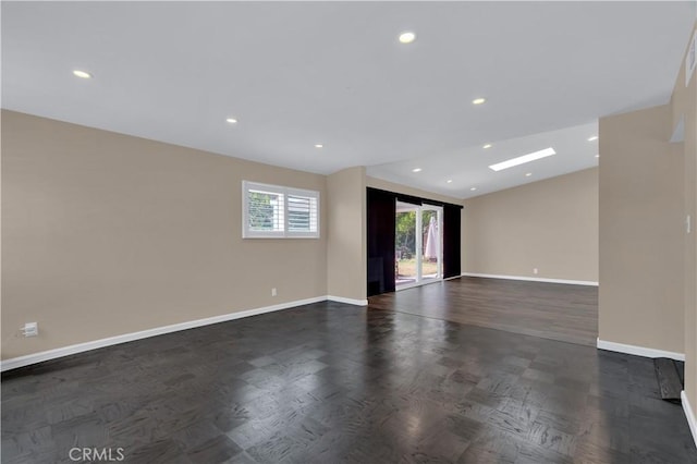 empty room featuring recessed lighting, lofted ceiling, and baseboards