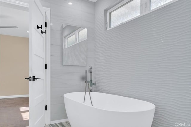 bathroom featuring a freestanding bath and tile walls