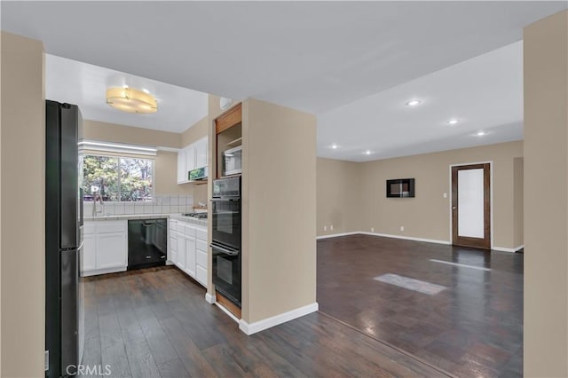 kitchen featuring dark wood-style floors, white cabinets, light countertops, and black appliances