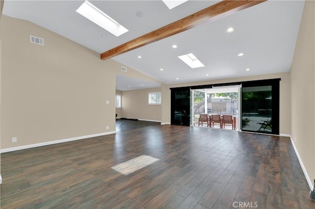 unfurnished living room featuring a skylight, beam ceiling, a wealth of natural light, visible vents, and wood finished floors