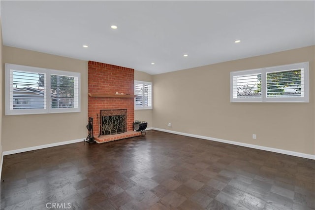 unfurnished living room with a brick fireplace, baseboards, and recessed lighting