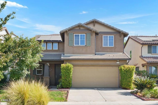 view of front of house featuring concrete driveway, a tile roof, and stucco siding