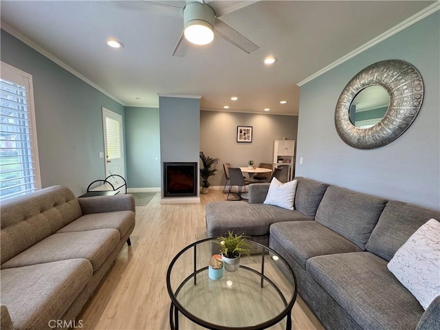 living room featuring recessed lighting, a fireplace, light wood-style floors, and baseboards