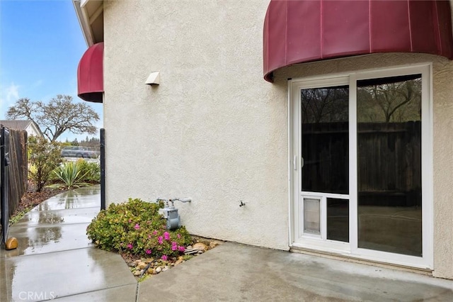 exterior space featuring fence, a patio, and stucco siding