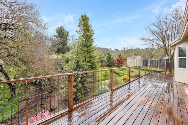 wooden deck with a storage unit and an outbuilding