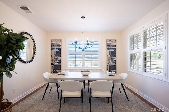 dining room featuring a chandelier, baseboards, visible vents, and a healthy amount of sunlight