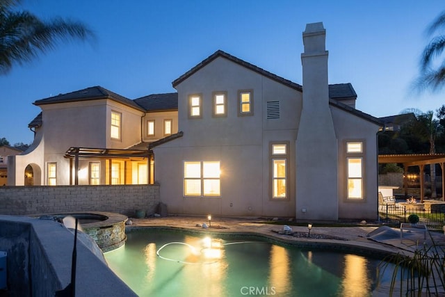 view of swimming pool featuring a pool with connected hot tub, a patio area, and a pergola