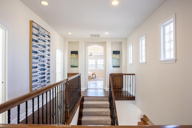 25663 Elmwood Ln, Valencia, CA 91381 - hall featuring baseboards, recessed lighting, an upstairs landing, visible vents, and arched walkways