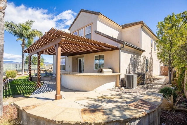 back of property with fence, central air condition unit, a patio area, a pergola, and stucco siding