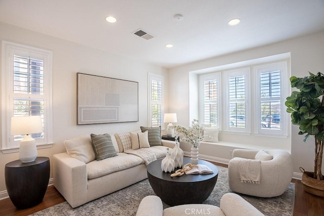 living room featuring plenty of natural light, visible vents, and wood finished floors