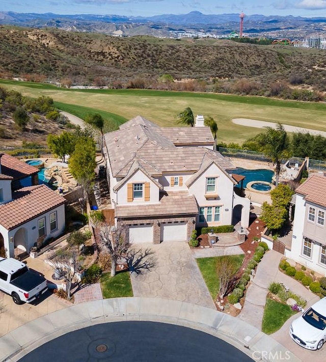 drone / aerial view with a mountain view and golf course view