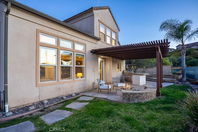 exterior space featuring an outdoor fire pit, fence, and a pergola