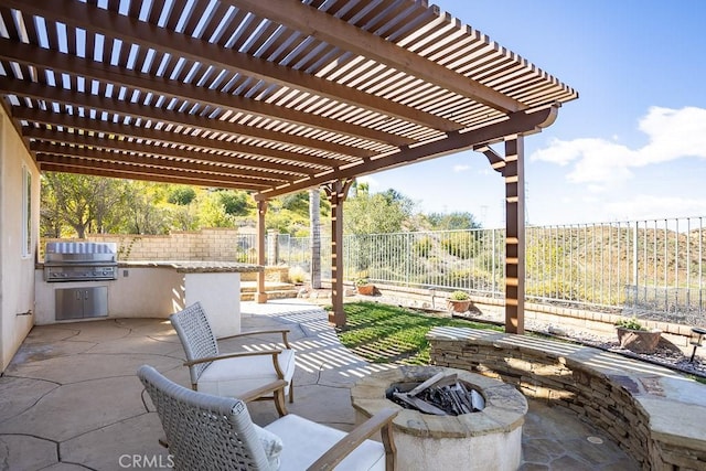 view of patio / terrace with a fire pit, exterior kitchen, grilling area, and a fenced backyard