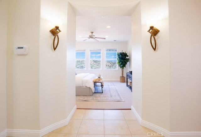 hall featuring recessed lighting, baseboards, and light tile patterned flooring