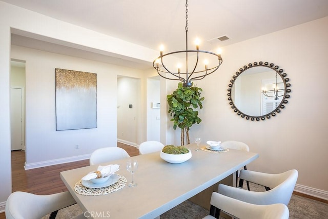 25663 Elmwood Ln, Valencia, CA 91381 - dining room with dark wood-type flooring, an inviting chandelier, baseboards, and visible vents
