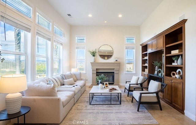 interior space with recessed lighting, visible vents, baseboards, a glass covered fireplace, and light tile patterned flooring