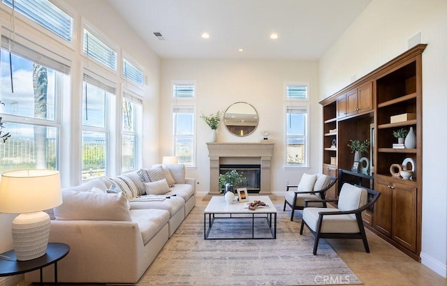 25663 Elmwood Ln, Valencia, CA 91381 - living area with a glass covered fireplace, visible vents, recessed lighting, light tile patterned flooring, and baseboards
