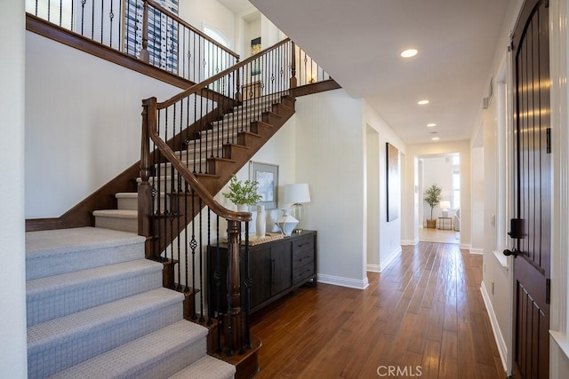 staircase featuring recessed lighting, hardwood / wood-style flooring, and baseboards