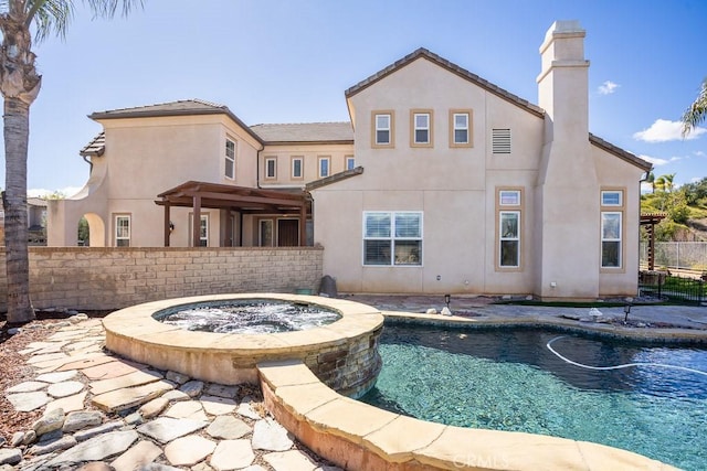 view of swimming pool with fence, a fenced in pool, and an in ground hot tub