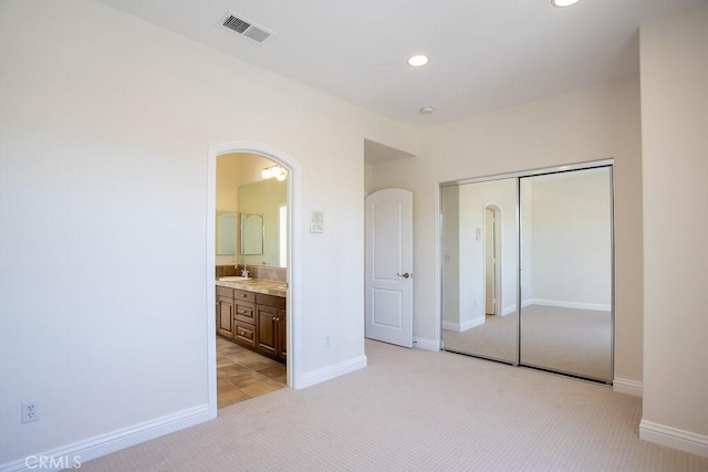 25663 Elmwood Ln, Valencia, CA 91381 - unfurnished bedroom featuring a closet, light carpet, visible vents, arched walkways, and a sink