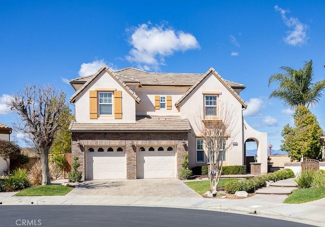 view of front of house featuring concrete driveway, a tile roof, an attached garage, and stucco siding