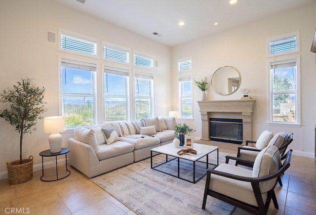 living room with baseboards, tile patterned floors, a glass covered fireplace, and recessed lighting