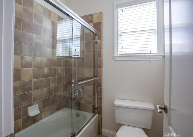 full bathroom featuring shower / bath combination with glass door and toilet