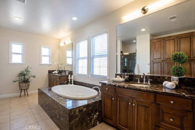 full bath featuring a bath, a sink, visible vents, and a healthy amount of sunlight