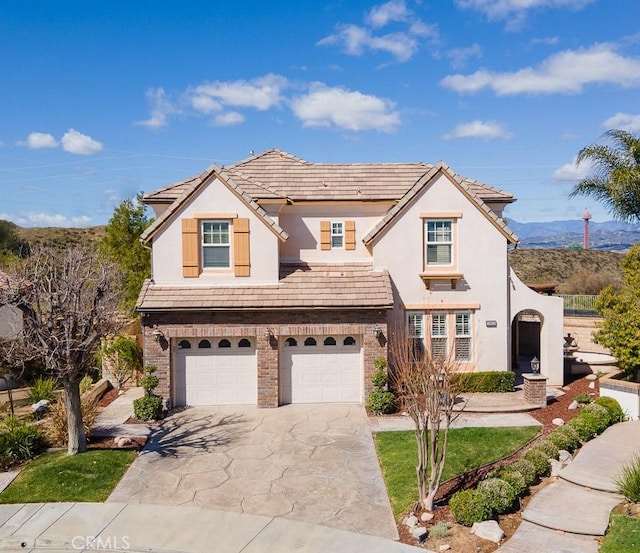 25663 Elmwood Ln, Valencia, CA 91381 - traditional-style home featuring a mountain view, an attached garage, concrete driveway, stucco siding, and brick siding