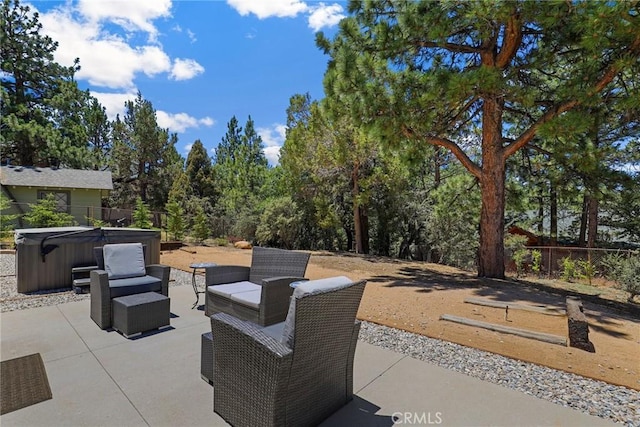 view of patio / terrace featuring fence, a hot tub, and an outdoor hangout area