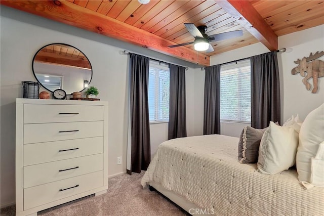 bedroom with a ceiling fan, wood ceiling, carpet flooring, and beamed ceiling