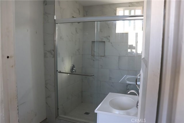 bathroom with a marble finish shower and vanity