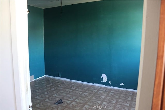 empty room featuring baseboards and tile patterned floors