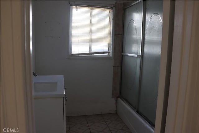 bathroom featuring enclosed tub / shower combo, tile patterned flooring, and vanity