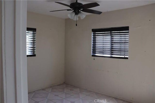 empty room with light floors and ceiling fan