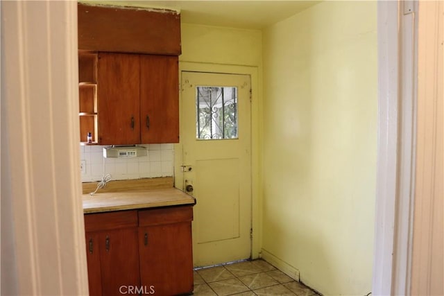 kitchen with tasteful backsplash, light tile patterned floors, light countertops, and open shelves