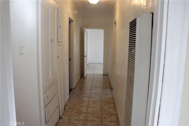 corridor featuring light tile patterned floors and a heating unit