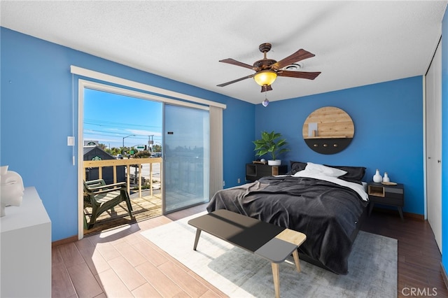 bedroom with access to exterior, ceiling fan, a textured ceiling, wood finished floors, and baseboards