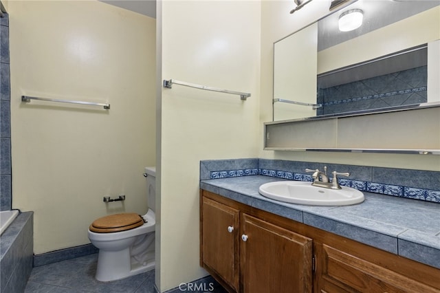 bathroom with tile patterned flooring, vanity, toilet, and tiled tub