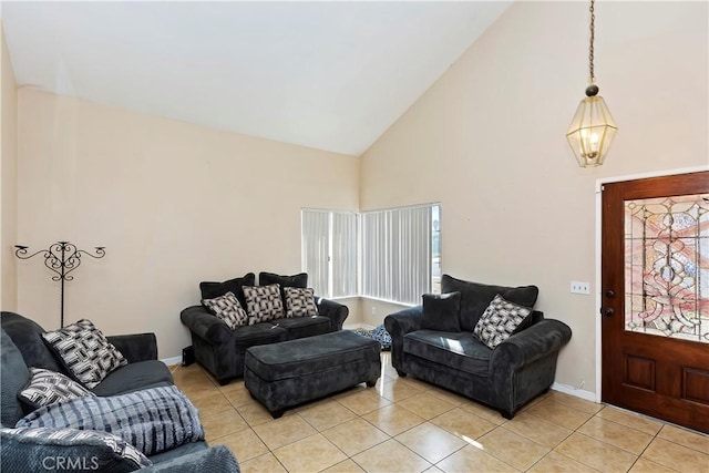 living room with light tile patterned floors, baseboards, and high vaulted ceiling