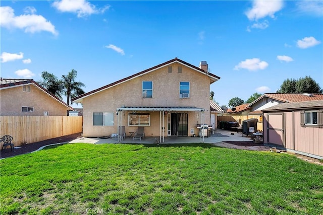 rear view of property with stucco siding, a patio, an outbuilding, and a fenced backyard