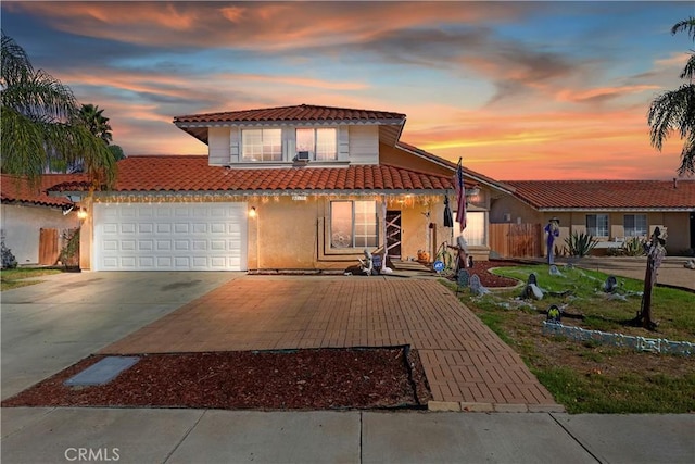 view of front of home featuring a tile roof, a garage, driveway, and stucco siding