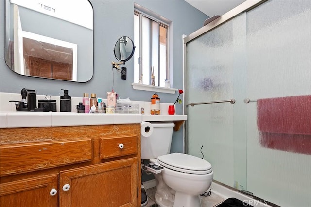 bathroom with vanity, a shower stall, toilet, and visible vents